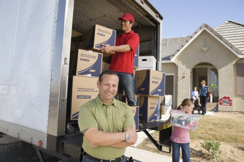 Man with van loading household items into a moving vehicle